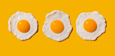 Three fried eggs on a yellow background