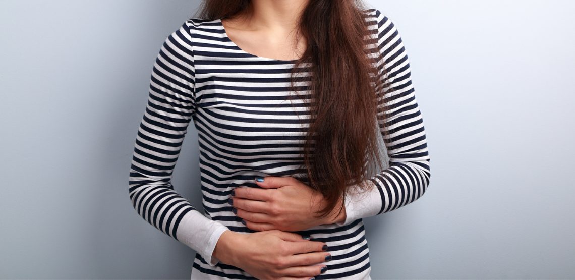 A woman in a striped shirt holding her stomach