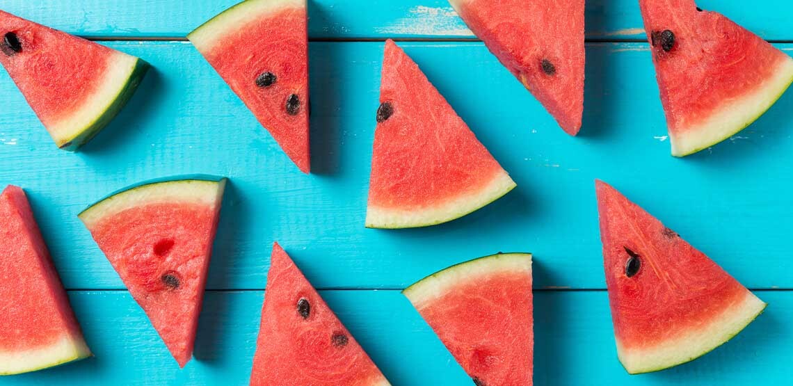 Slices of watermelon against a teal background.