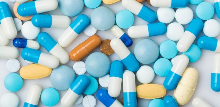 An assortment of blue and white pills laid out on a table