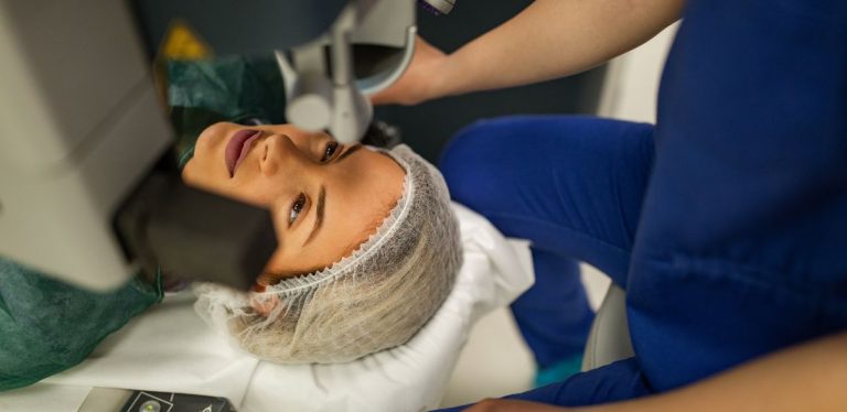 A woman laying down getting laser eye treatment.